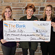 Staff holding large check for United Way donation