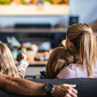 Image of parents on couch with young children, relaxing in front of the TV.