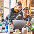Young couple discussing while using laptop at home